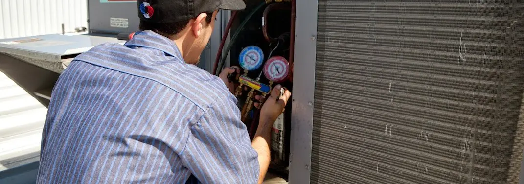 HVAC technician servicing a condenser unit in Golden Gate