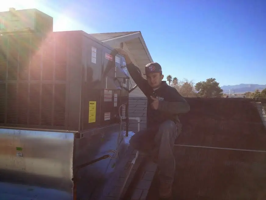 HVAC technician performing AC Tune-Up on a rooftop unit in Golden Gate